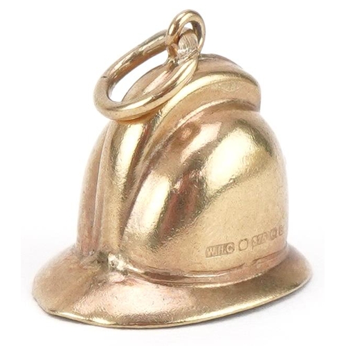 3385 - Unmarked gold charm in the form of a policeman's helmet, 1.3cm high, 1.1g