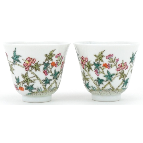 1017 - Pair of Chinese porcelain tea bowls hand painted with flowers, six figure character mark to the base... 