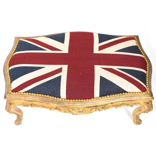 708 - 20th century carved giltwood serpentine fronted stool, overstuffed and upholstered in a Union Jack s... 