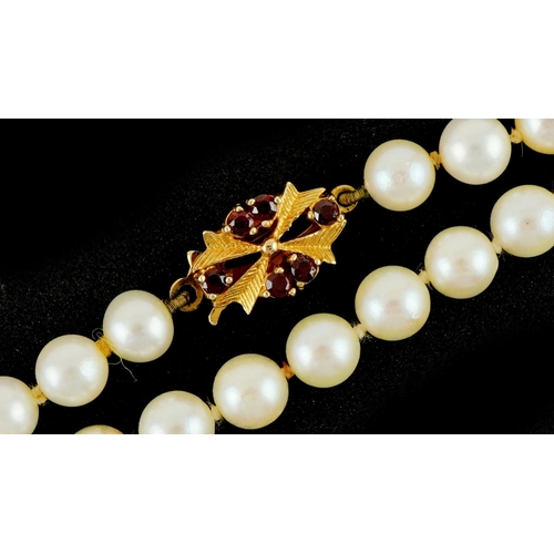 3335 - Cultured pearl necklace with 9ct gold garnet clasp, 44cm in length, 23.6g