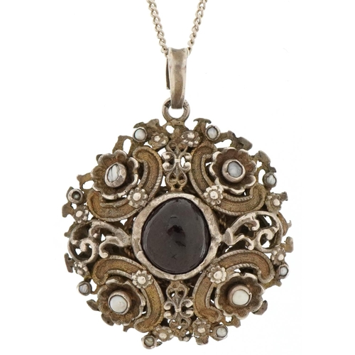 Unmarked silver, garnet and pearl pendant on a white metal necklace, possibly Austro-Hungarian, the pendant 3.5cm in diameter, total 15.5g