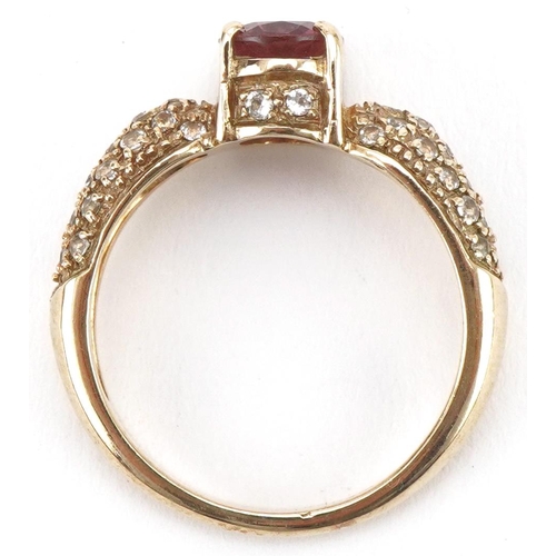 3228 - 9ct gold garnet solitaire ring, the shoulders set with white spinels, size N, 3.8g