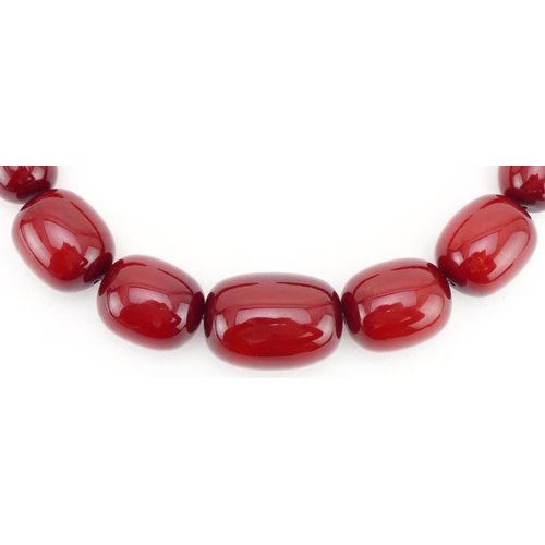 3024 - Large cherry amber coloured bead necklace, the largest bead approximately 40mm in length x 29mm in d... 