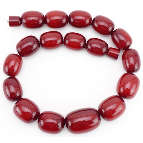 3024 - Large cherry amber coloured bead necklace, the largest bead approximately 40mm in length x 29mm in d... 