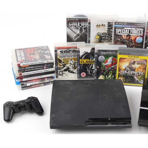 2370 - Two Sony PlayStation 3 games consoles with controllers and a collection of games