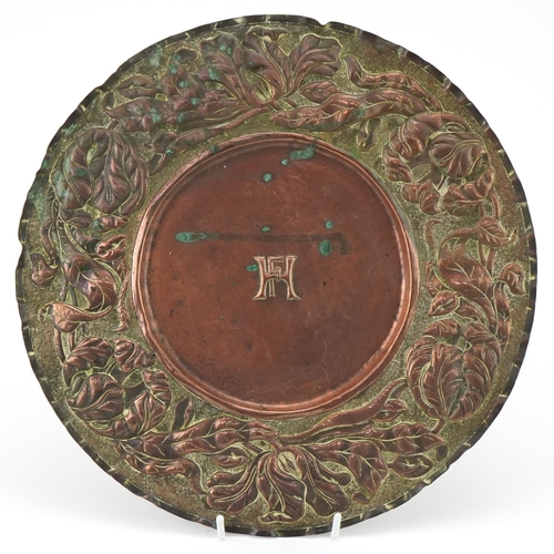 107 - Arts & Crafts copper plate with stylized floral border, initial HF to the centre, 30cm in diameter