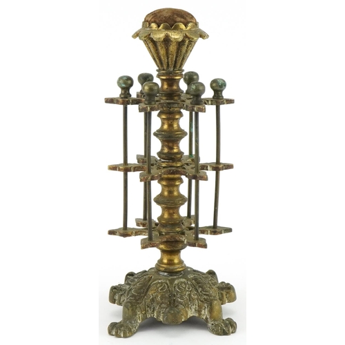 1312 - Victorian brass cotton reel stand with velvet padded top mounted on lion paw feet, 26cm high