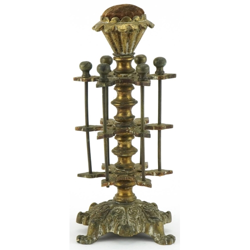 1312 - Victorian brass cotton reel stand with velvet padded top mounted on lion paw feet, 26cm high