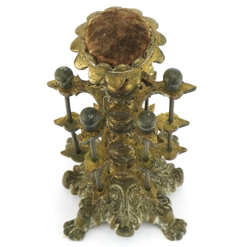 1312 - Victorian brass cotton reel stand with velvet padded top mounted on lion paw feet, 26cm high