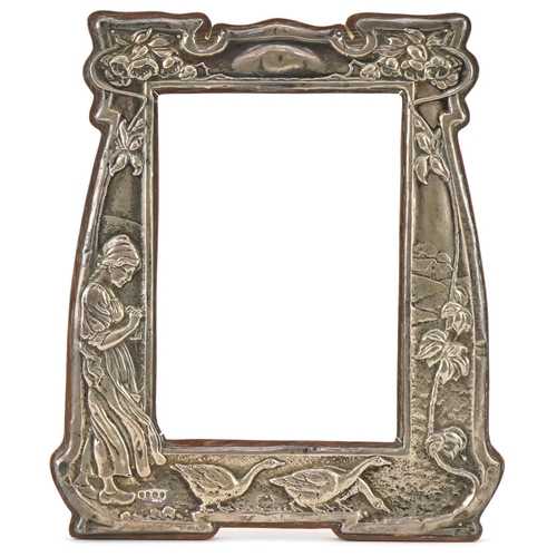 64 - Charles S Green & Co Ltd, Art Nouveau silver photo frame embossed with a Dutch girl feeding geese an... 