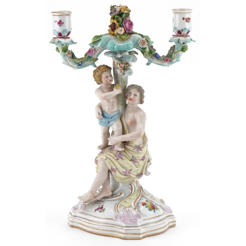 1102 - Continental porcelain floral encrusted candelabra of a mother and child, impressed number 123 to the... 