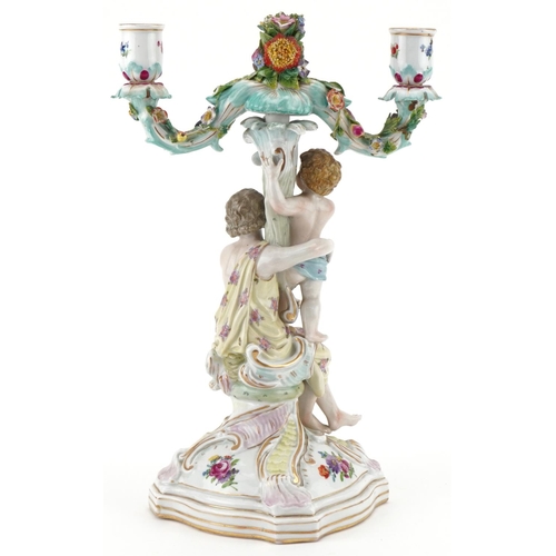 1102 - Continental porcelain floral encrusted candelabra of a mother and child, impressed number 123 to the... 