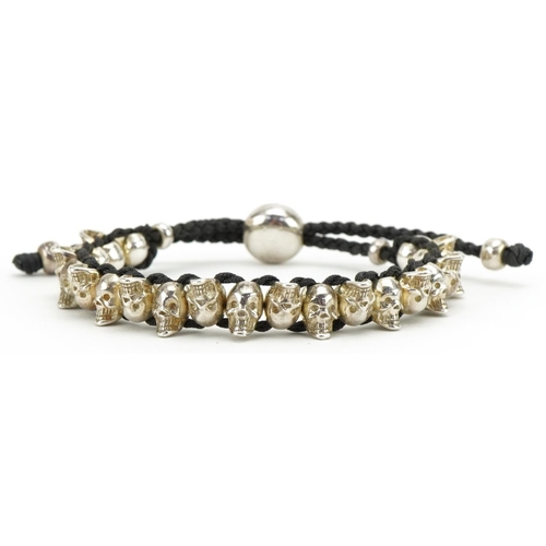 3510 - Links of London, sterling silver and cord bracelet in the form of human skulls, 20cm in length, 33.0... 