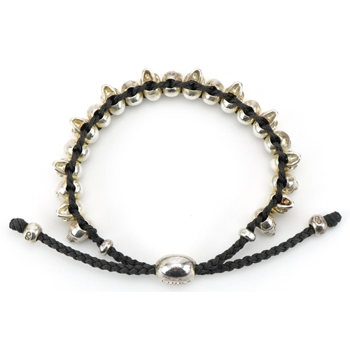 3510 - Links of London, sterling silver and cord bracelet in the form of human skulls, 20cm in length, 33.0... 