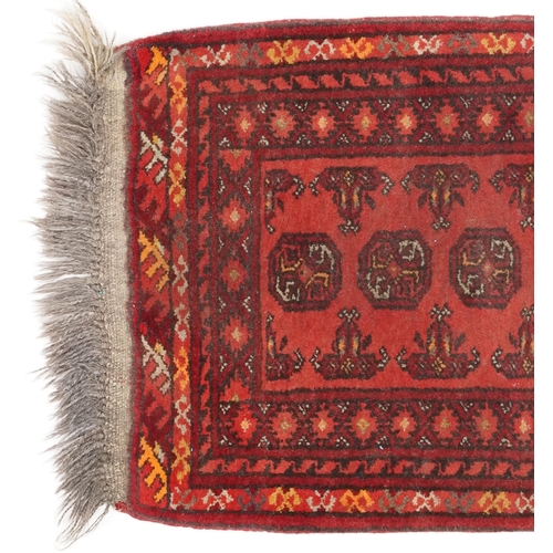 746 - Afghan rug, late 20th century the red field with a single row of guls, 65cm x 51cm