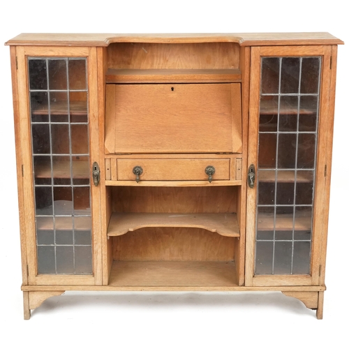 598 - Early 20th century Arts & Crafts style oak bureau bookcase fitted with a pair of leaded glazed doors... 