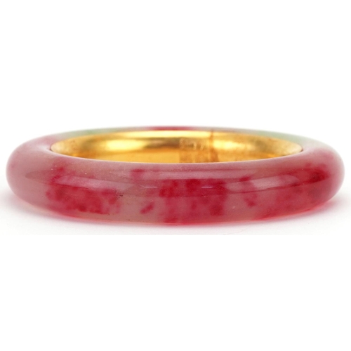 3427 - Chinese multi coloured jade and gilt metal bangle, impressed marks to the interior, 9cm in diameter,... 