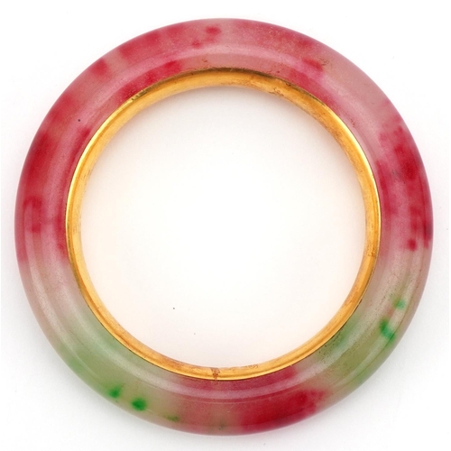 3427 - Chinese multi coloured jade and gilt metal bangle, impressed marks to the interior, 9cm in diameter,... 