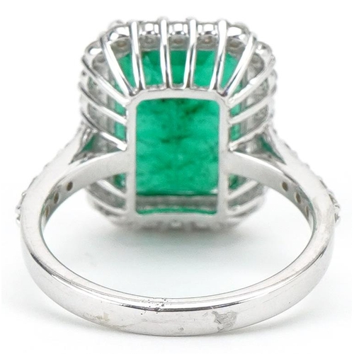 3085 - 18ct white gold emerald and diamond cluster ring with diamond set shoulders, the emerald approximate... 