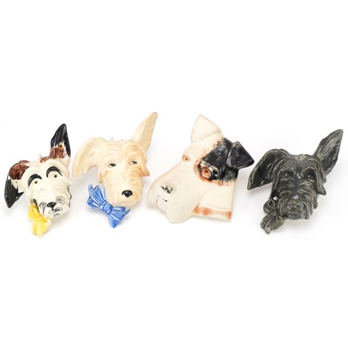 427 - Four terrier dog wall plaques including a plaster example, the tallest 17cms high