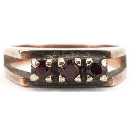 3406 - 9ct gold garnet three stone ring, size N, 3.6g