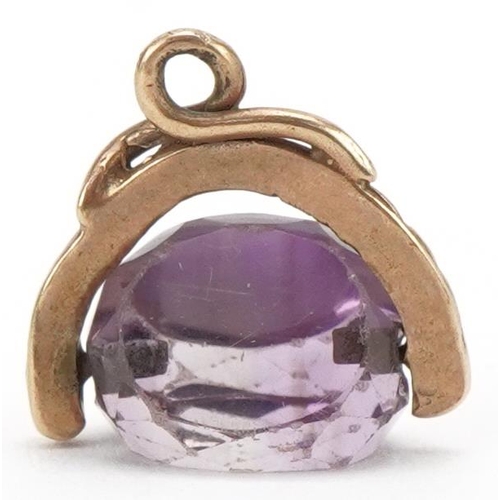 3184 - Unmarked gold amethyst spinner fob, 1.6cm wide, 2.6g