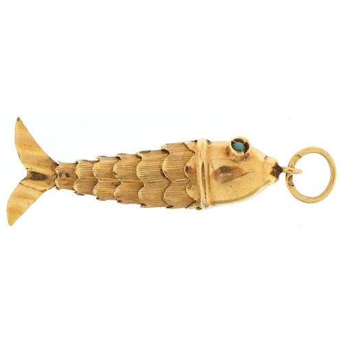 3214 - Continental gold articulated fish charm with turquoise eyes, 3.8cm in length, 1.7g