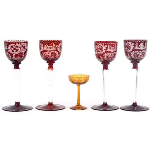 252 - Four Bohemian red flashed glasses etched with wild animals and foliage together with an amber glass ... 