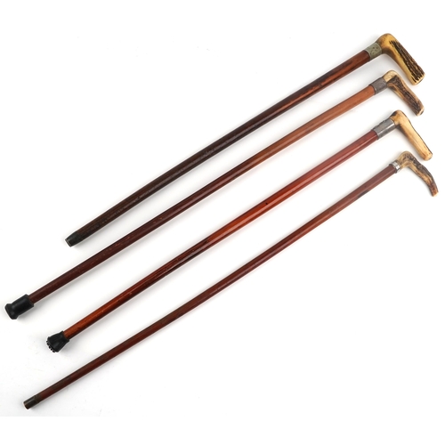 219 - Four walking sticks with horn handles, one with silver collar, the largest 88cm in length