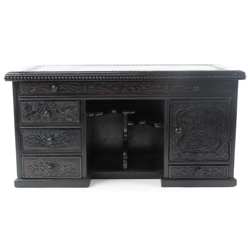 340 - Chinese carved wood table top cabinet in the form of a desk fitted with a series of drawers, 33cm H ... 