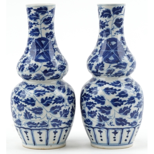 147 - Pair of Chinese blue and white porcelain double gourd vases hand painted with foliage, 24cm high