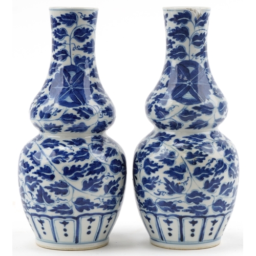 147 - Pair of Chinese blue and white porcelain double gourd vases hand painted with foliage, 24cm high