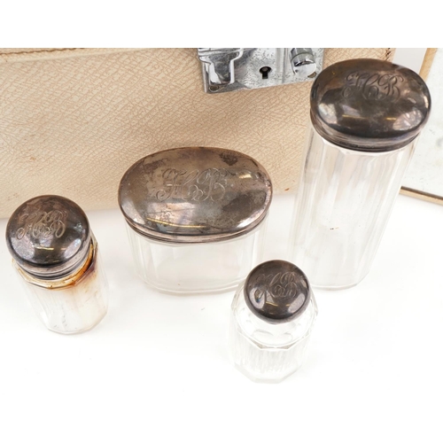 482 - Vintage cream leather travelling vanity case with five glass jars with silver tops, 36cm wide