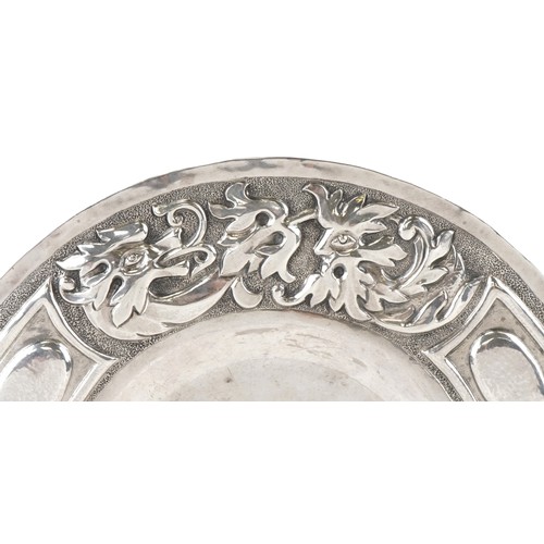 62 - W G Connell, Arts & Crafts circular silver dish embossed with stylized dragon and Green Man, London ... 