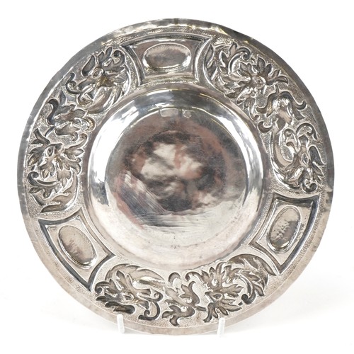 62 - W G Connell, Arts & Crafts circular silver dish embossed with stylized dragon and Green Man, London ... 