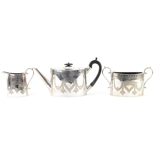 1229 - Silver plated three piece tea service engraved with swags and flowers, the teapot with ebonised hand... 