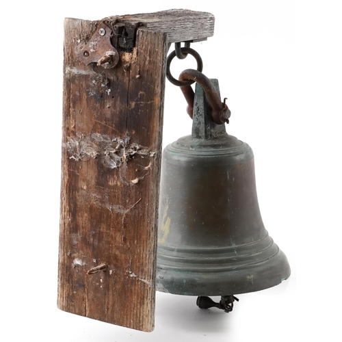 2405 - Patinated bronze ship's bell with wooden bracket mount, the bell 28cm high