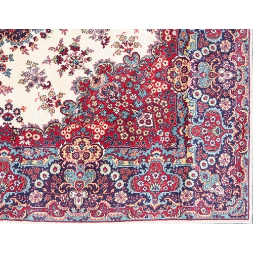 1015 - Rectangular Persian Tabriz rug having and allover floral design onto a cream, red and blue ground, 3... 