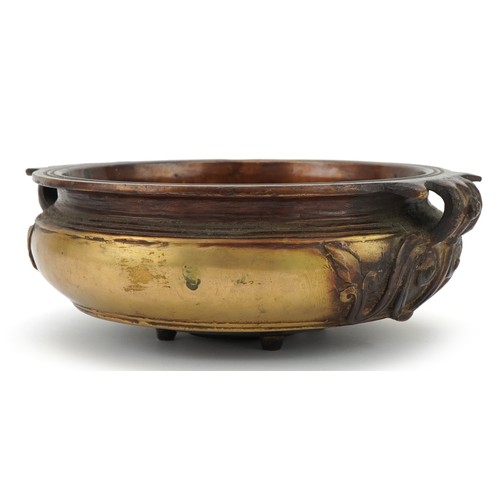 Bronze Art Nouveau bowl with floral handles mounted on four tripod feet, 23cm in diameter