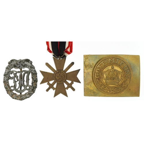 2594 - German militaria comprising World War I brass dress buckle, World War II sports badge and War Merit ... 