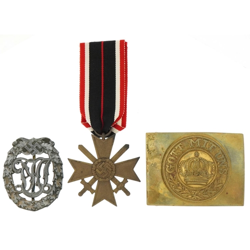 2594 - German militaria comprising World War I brass dress buckle, World War II sports badge and War Merit ... 