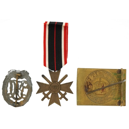 2594 - German militaria comprising World War I brass dress buckle, World War II sports badge and War Merit ... 