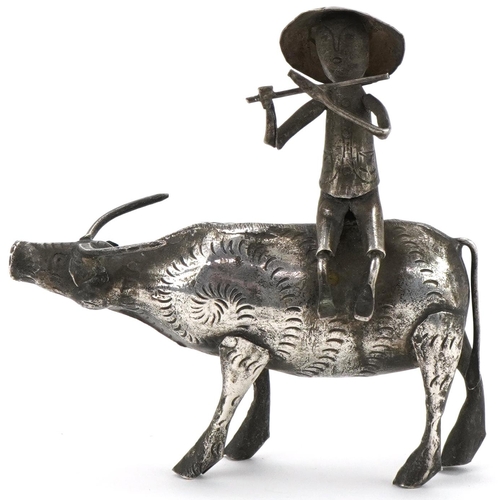 366 - Middle Eastern white metal study of a figure seated on a cow, 10cm in length, 51.2g