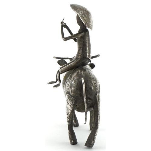 366 - Middle Eastern white metal study of a figure seated on a cow, 10cm in length, 51.2g