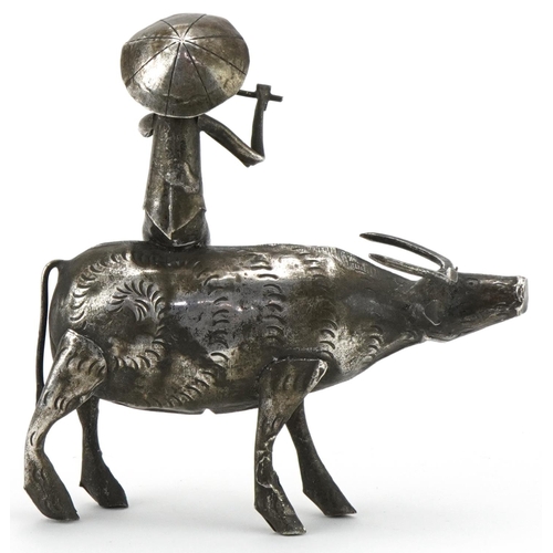 366 - Middle Eastern white metal study of a figure seated on a cow, 10cm in length, 51.2g