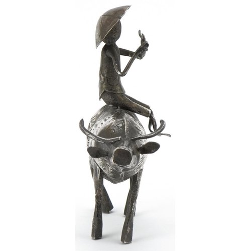 366 - Middle Eastern white metal study of a figure seated on a cow, 10cm in length, 51.2g