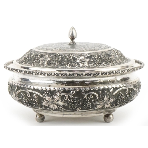  Middle Eastern silver bowl and cover raised on three ball feet profusely embossed with fruit on vine... 