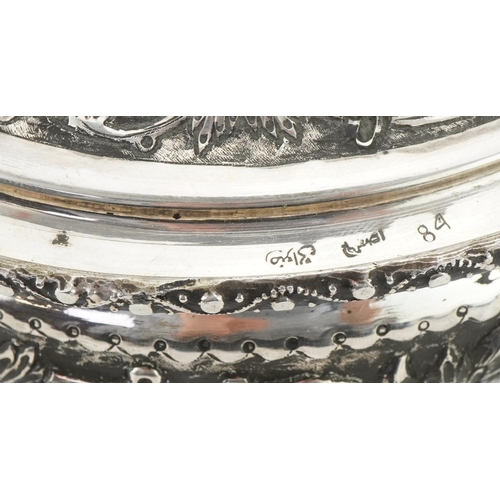  Middle Eastern silver bowl and cover raised on three ball feet profusely embossed with fruit on vine... 