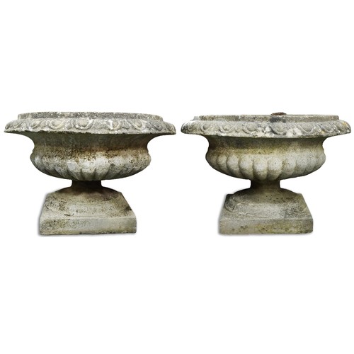 766 - Pair of 20th century cast composition stone garden urns of half reeded form, on plinth bases, H-40cm... 