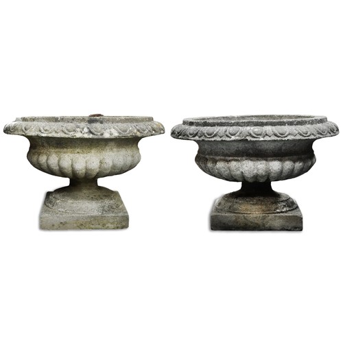 766 - Pair of 20th century cast composition stone garden urns of half reeded form, on plinth bases, H-40cm... 